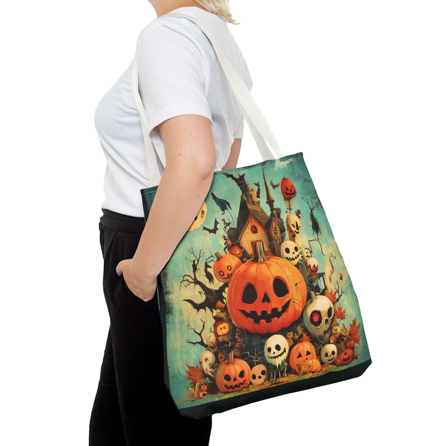 Woman carrying a tote bag featuring a vibrant all-over print of jack o' lanterns and haunted house, perfect for Halloween.