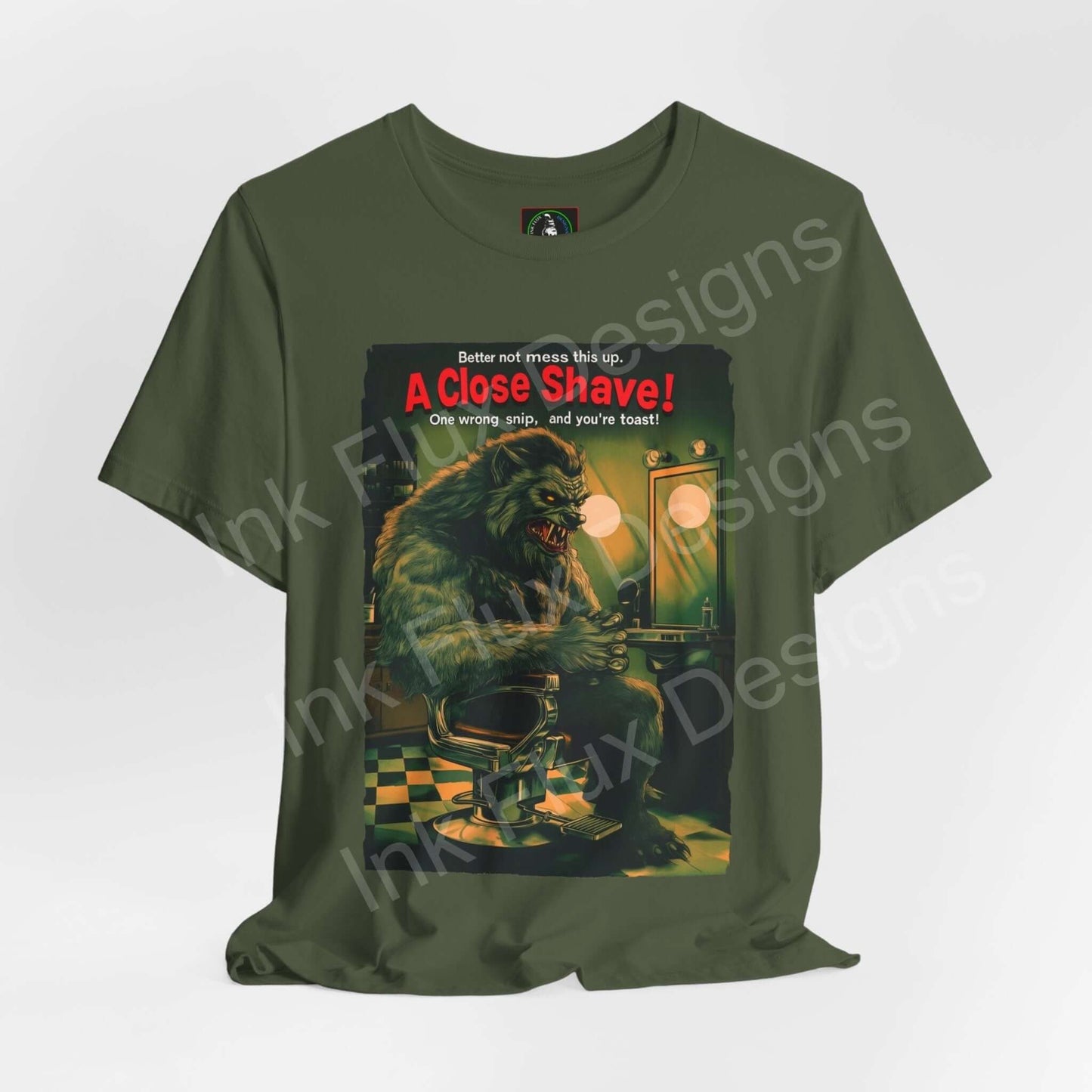 Halloween-themed graphic tee featuring a werewolf in a barbershop scene with "A Close Shave!" text, in olive green, unisex fit, by Bella+Canvas.