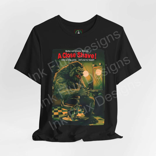 Halloween-themed graphic tee "A Close Shave!" featuring a monstrous figure in a barbershop setting, from Bella+Canvas unisex jersey collection.