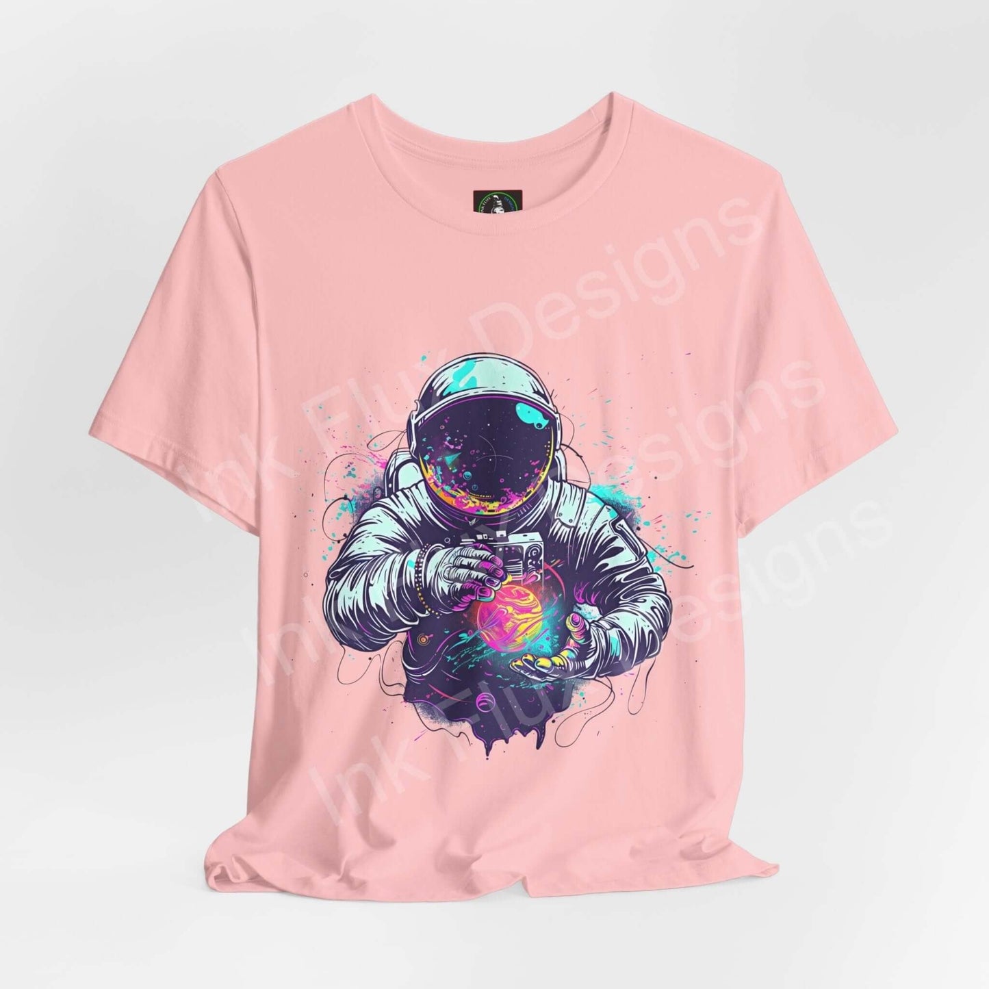 Unisex pink T-shirt featuring bold graphic of an astronaut holding a galaxy, crafted from Airlume cotton, ideal for style and comfort.