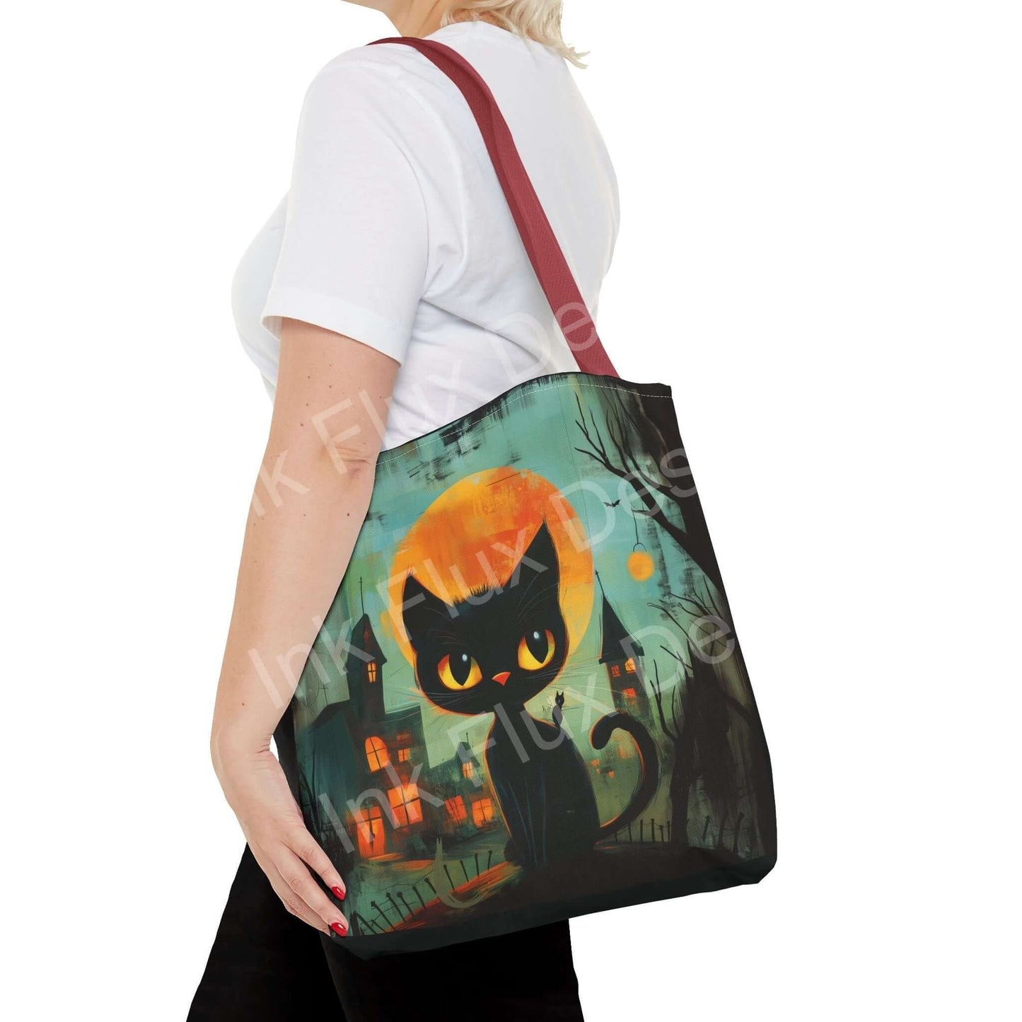 Woman carrying a black cat painting tote bag with a spooky Halloween-themed design, showcasing durable red straps and high-quality print.