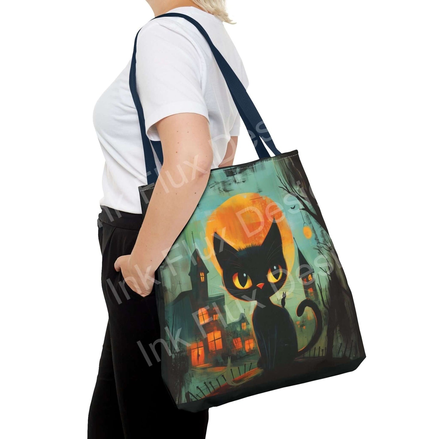 Woman carrying a black cat painting tote bag, featuring a vibrant all-over print design set against a spooky town backdrop, available in various sizes and handle colors.