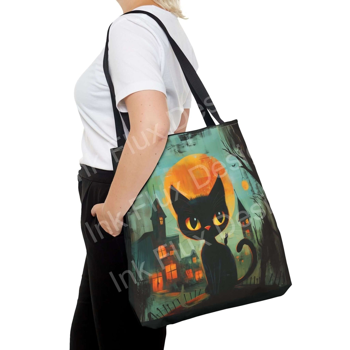 Woman carrying a black cat painting tote bag with colorful haunted house design, showcasing durable straps and high-quality print.