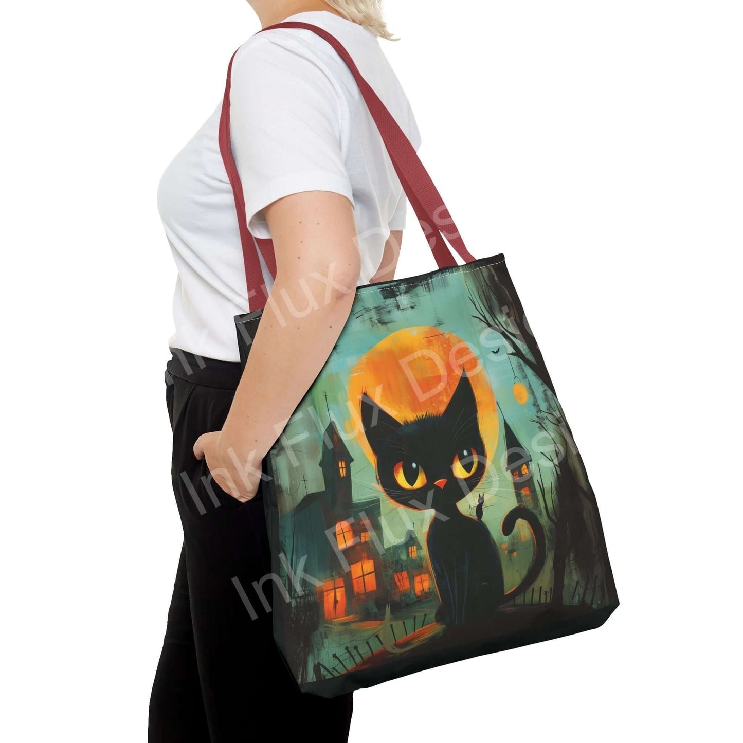 Woman carrying a black cat painting tote bag with an all-over print design and red handles, showcasing the bag's large size and vivid artwork.