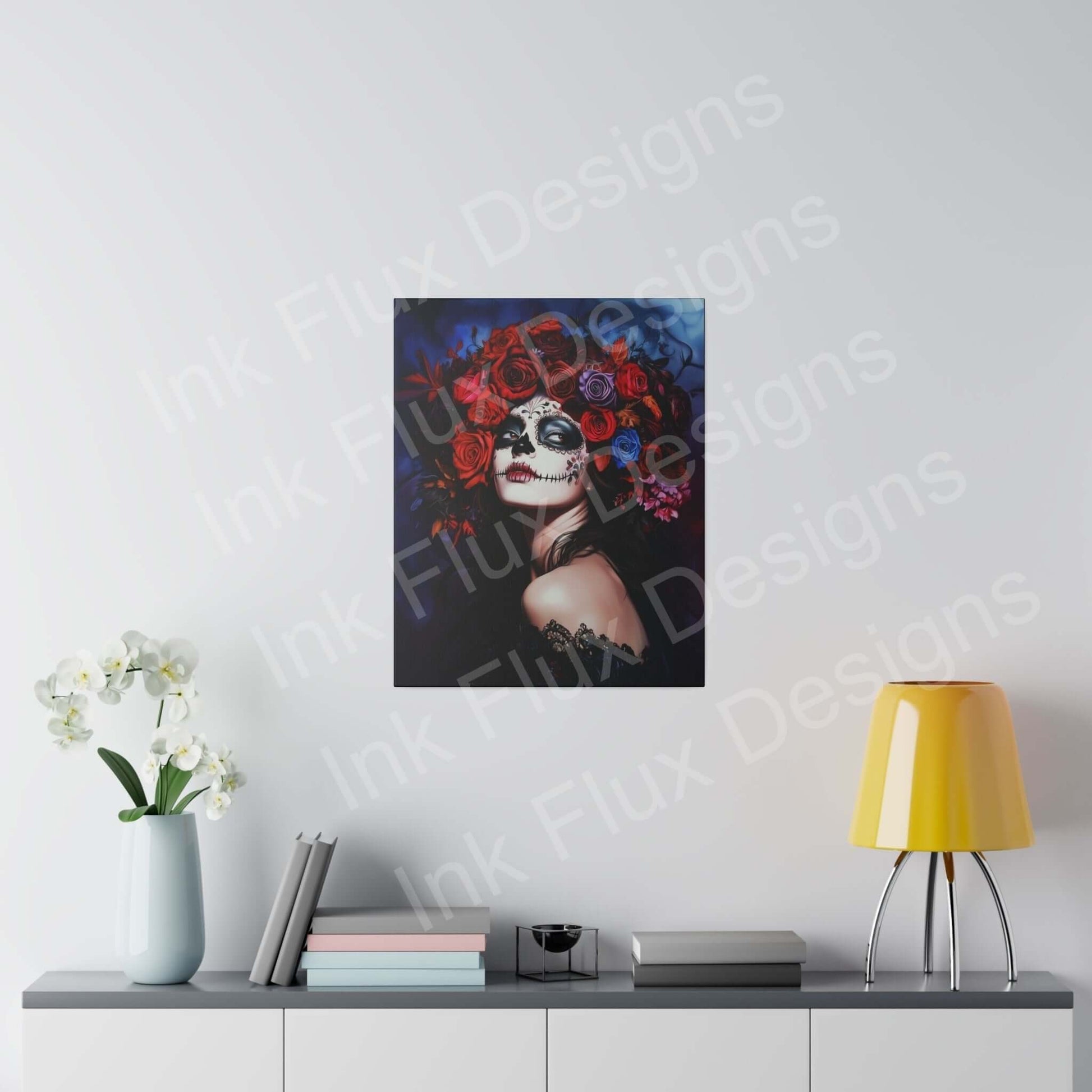 Bold Day of the Dead woman's portrait on eco-friendly stretched canvas with vibrant red flowers, displayed above a modern gray console with decorative items.