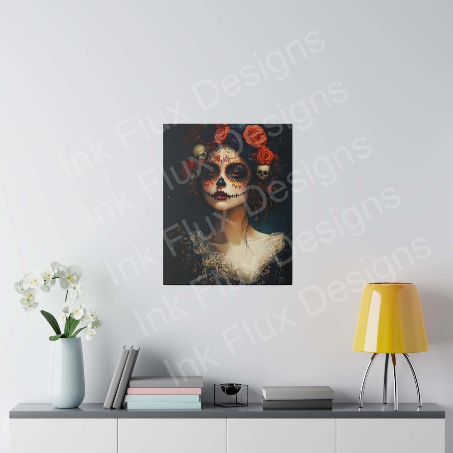 Canvas print of a Day of the Dead woman's portrait with bold designs, hanging above a modern console with a yellow lamp and white orchids.
