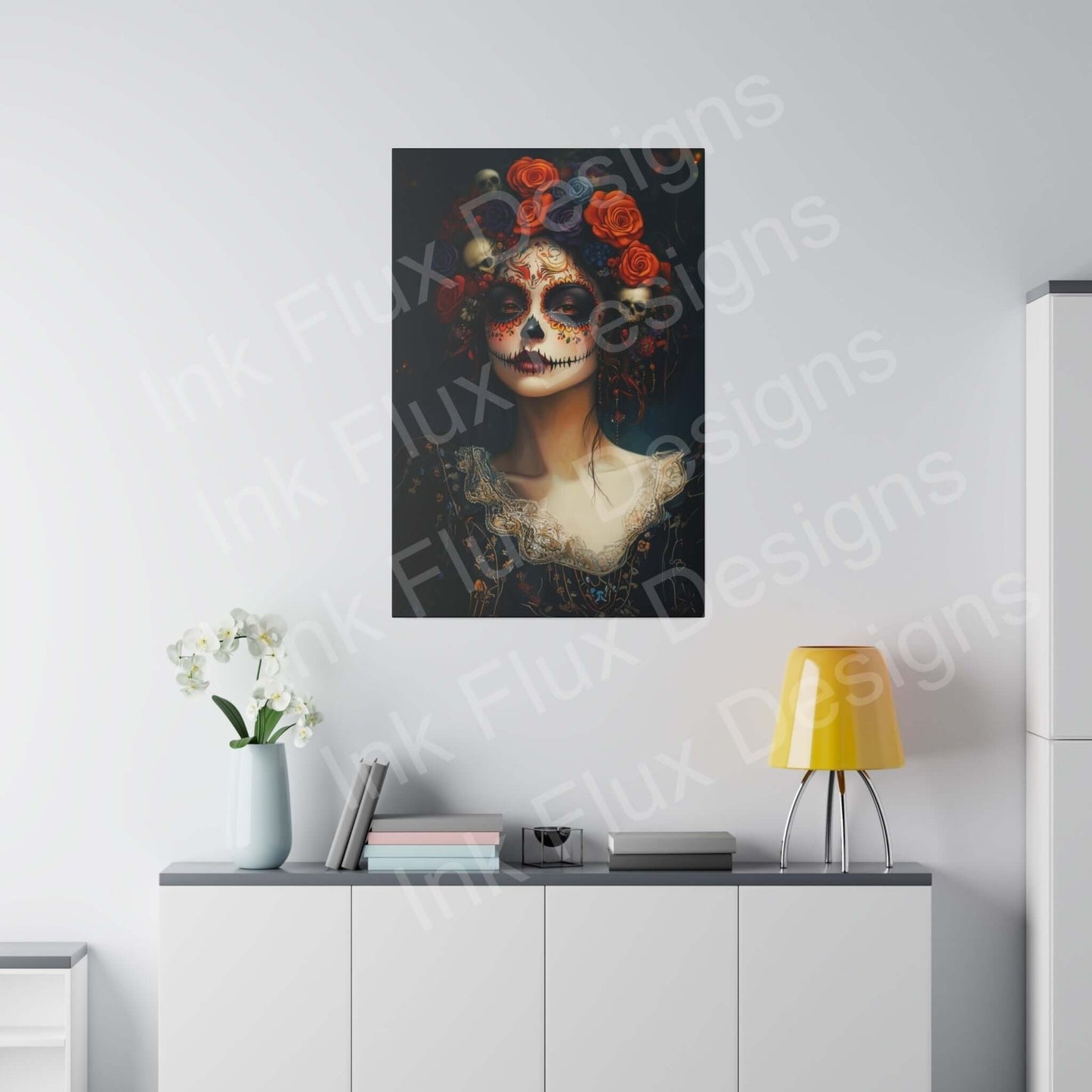 Day of the Dead woman portrait canvas with bold designs in a modern room on white sideboard with lamp and flowers.