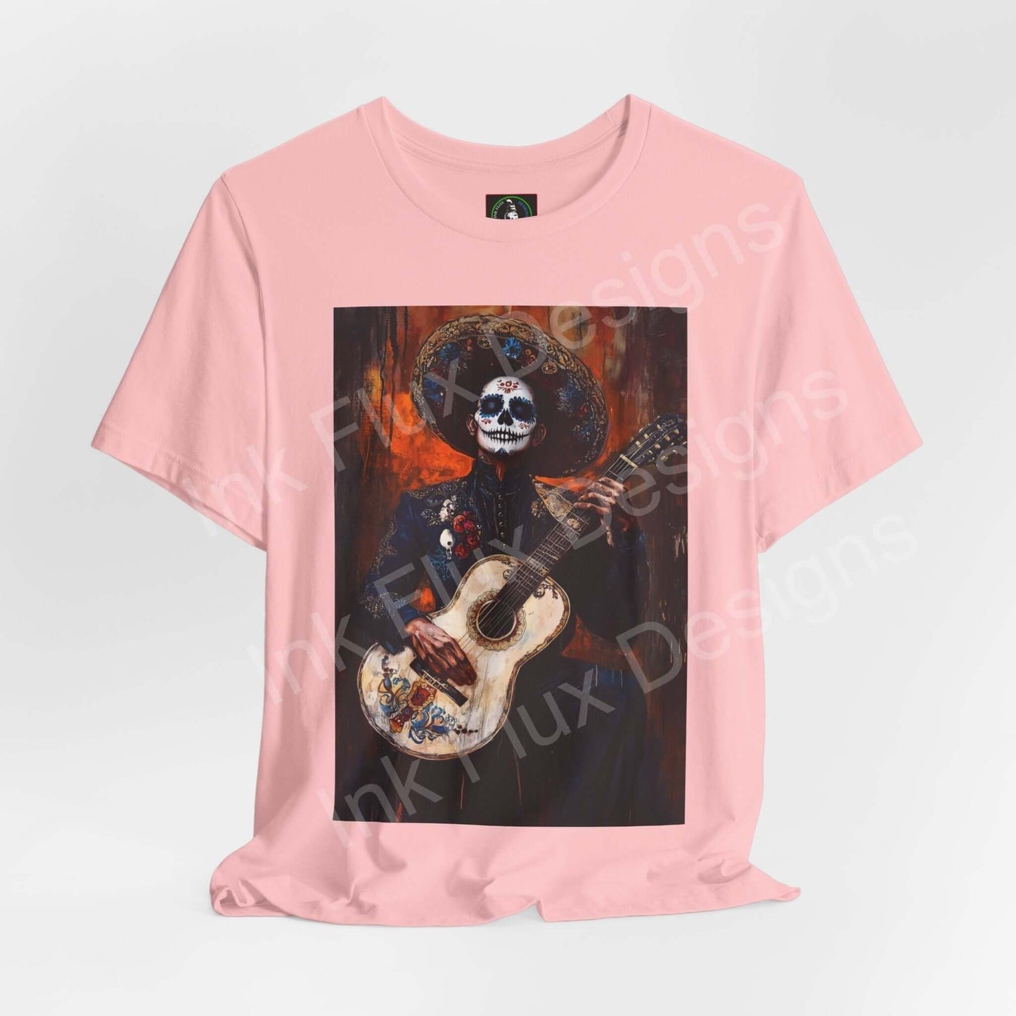 Pink unisex T-shirt with Day of the Dead Charro Man graphic, featuring a skeleton in traditional attire playing a guitar, ideal for DÃa de Muertos celebrations.