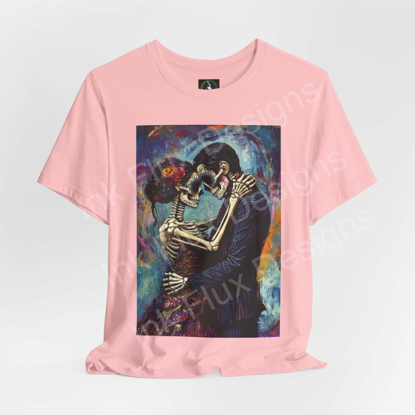Pink unisex T-shirt featuring a Day of the Dead graphic design with a couple embracing, embodying the DÃa de Muertos spirit, ideal for stylish, ethically-made apparel.