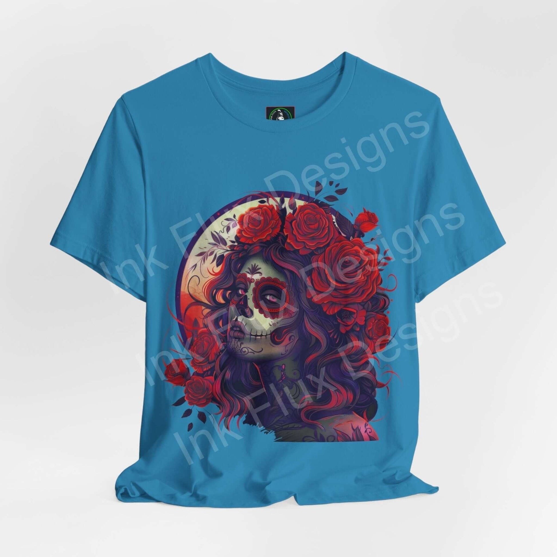 Day of the Dead themed graphic tee featuring a vibrant DÃa de Muertos skull design with floral accents, on a blue unisex T-shirt.
