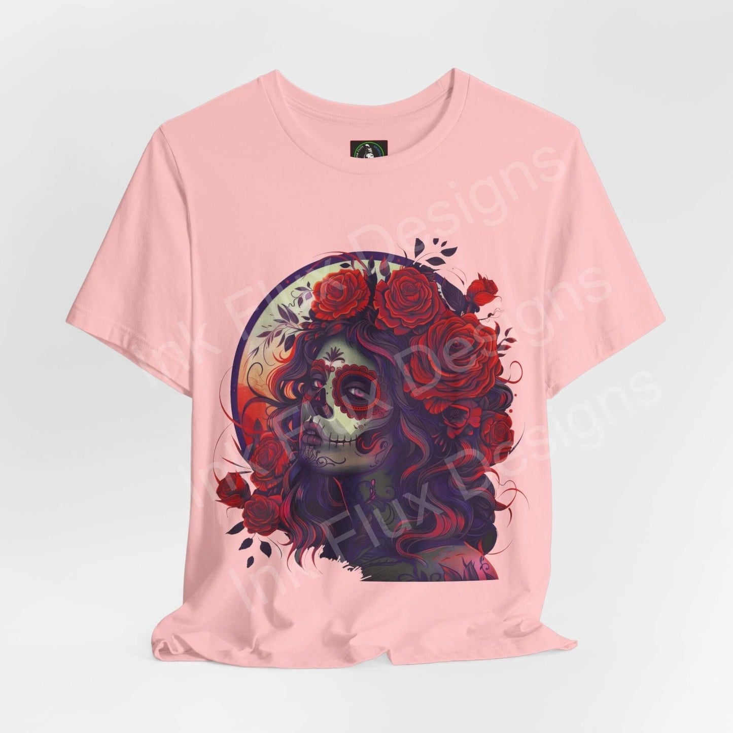 Pink unisex T-shirt with a detailed Day of the Dead graphic design featuring a colorful sugar skull and roses, from Bella+Canvas.