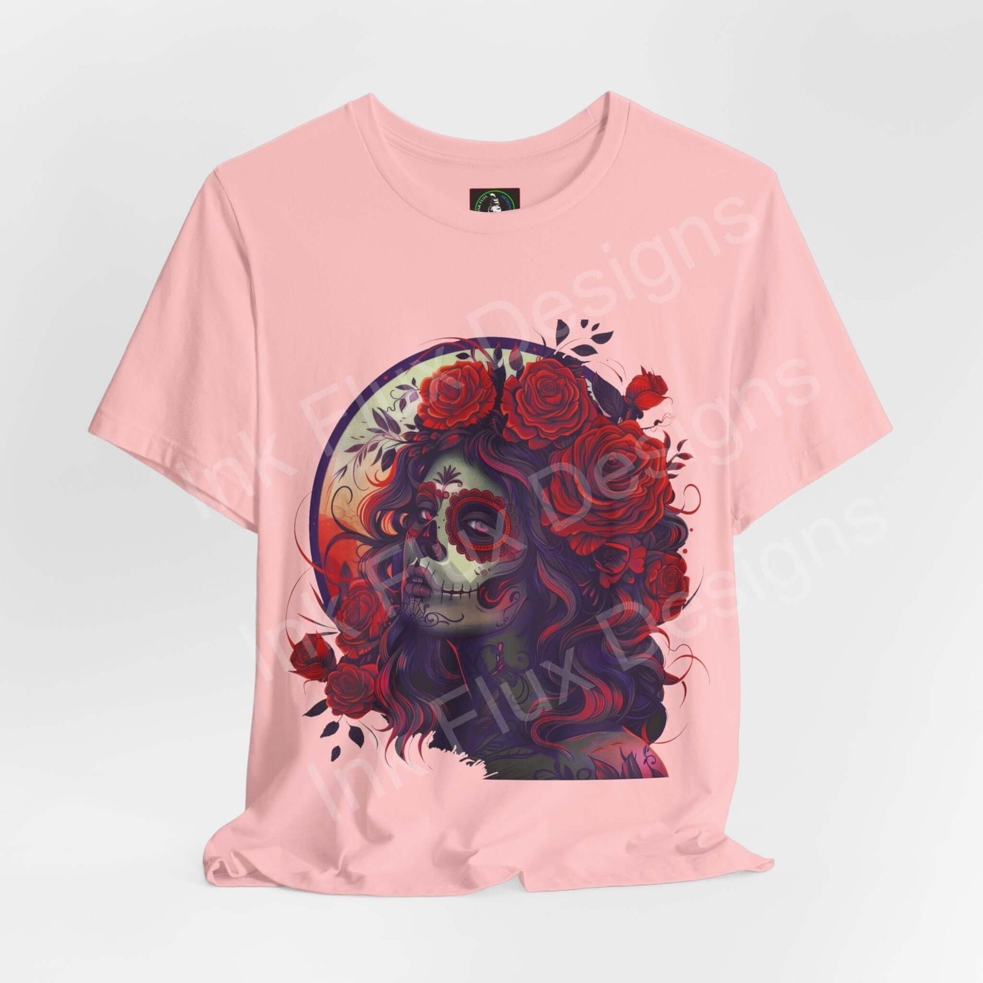 Pink unisex T-shirt with a detailed Day of the Dead graphic design featuring a colorful sugar skull and roses, from Bella+Canvas.