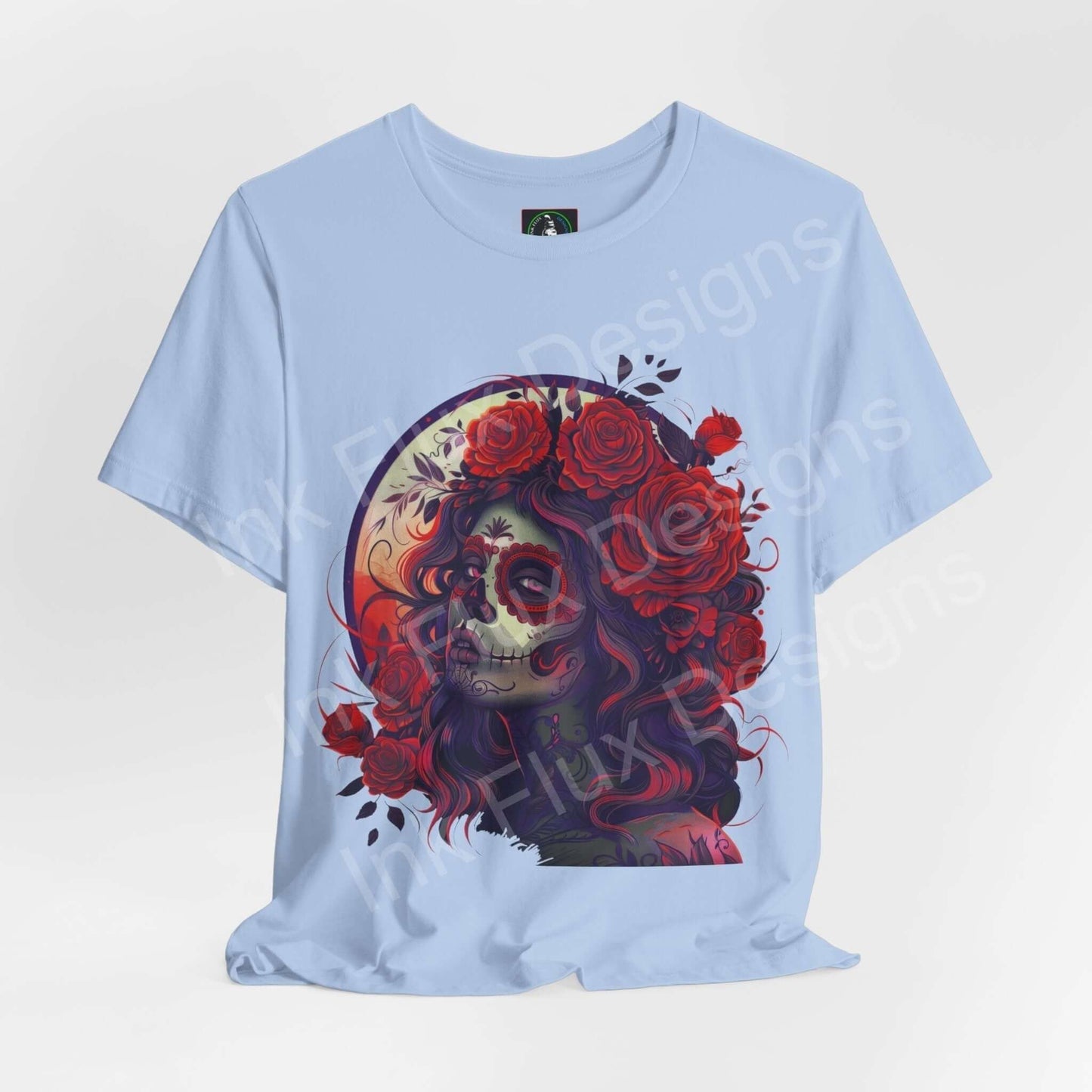 Light blue unisex T-shirt featuring a vibrant Day of the Dead graphic with a skull adorned with roses, ideal for DÃa de Muertos celebrations.