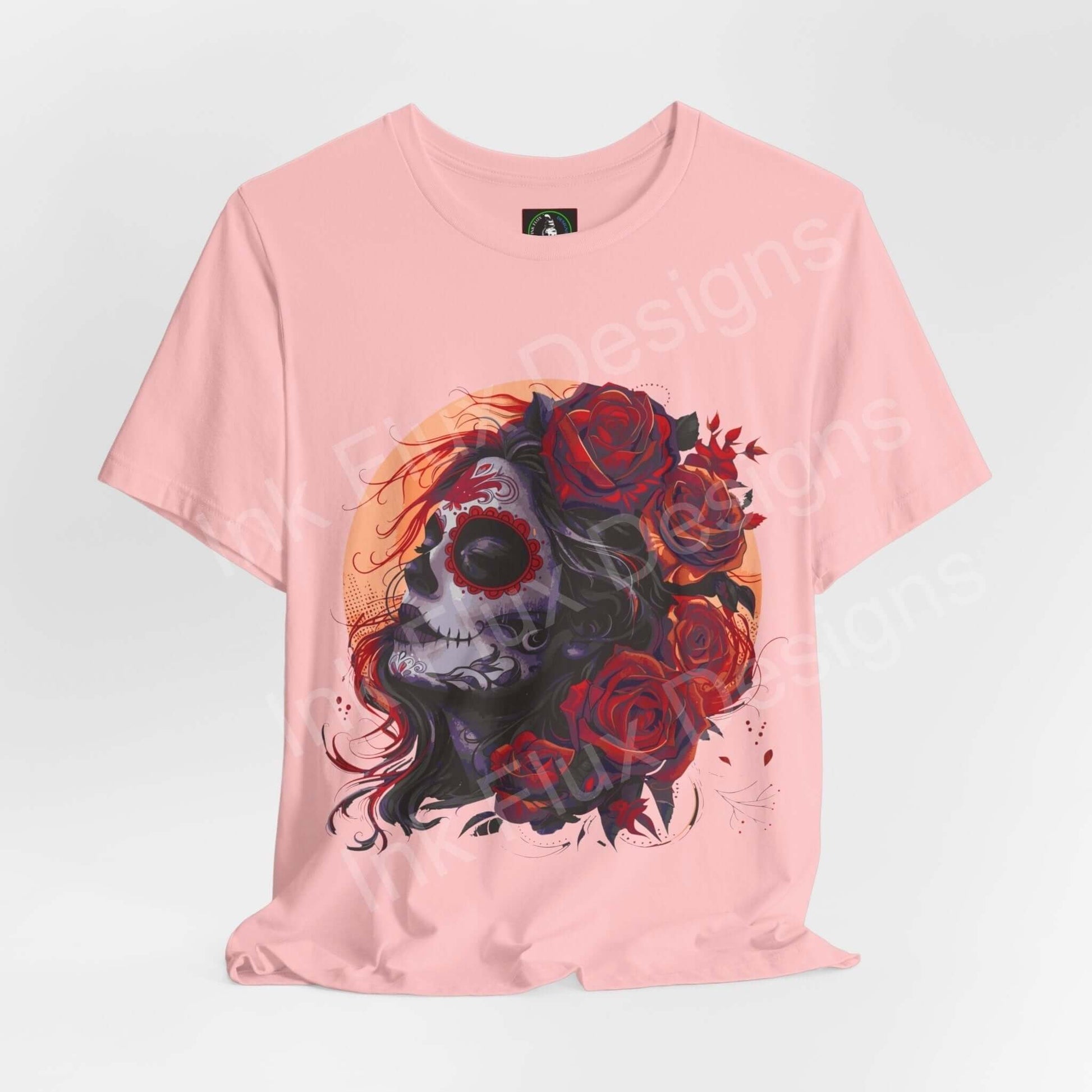 Day of the Dead inspired graphic tee featuring a skull and roses design on a pink, unisex Bella+Canvas T-shirt, perfect for DÃa de Muertos celebrations.
