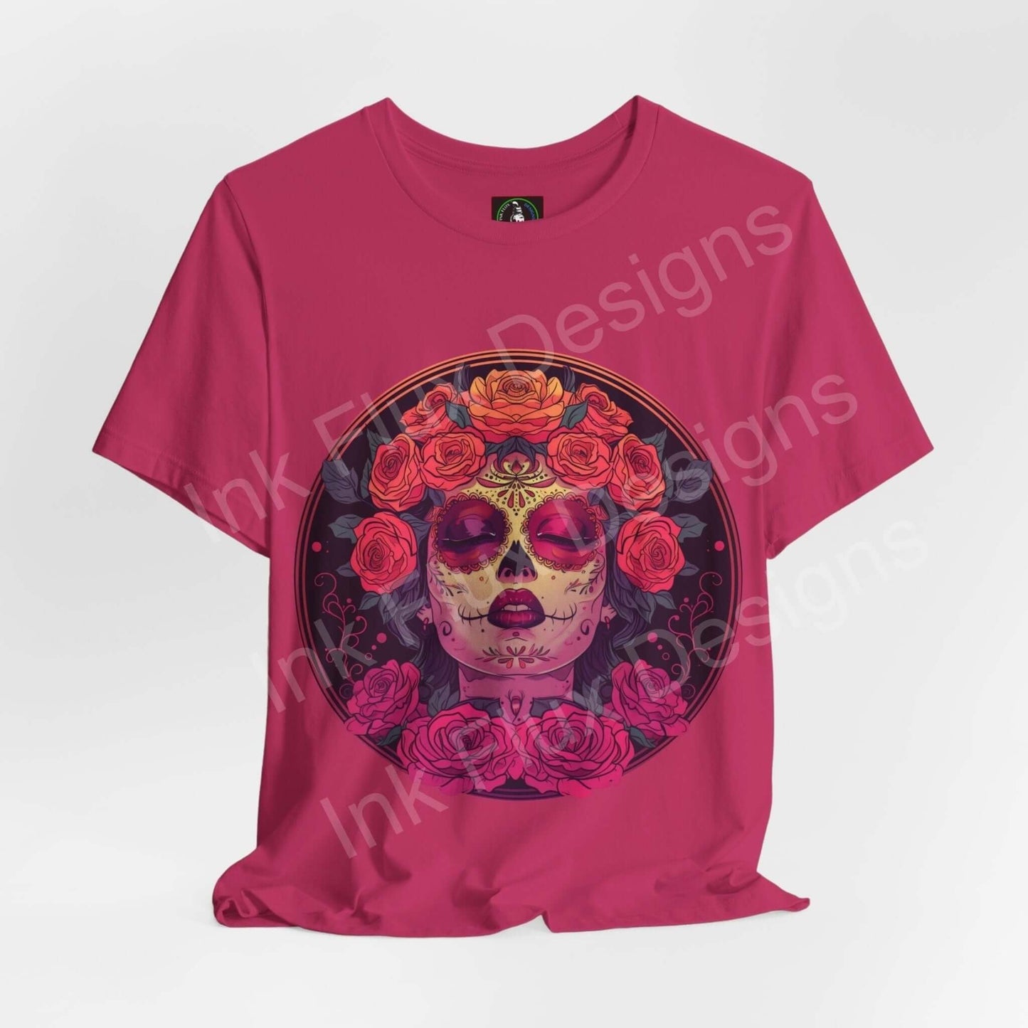 Pink Day of the Dead graphic tee featuring a bold DÃa de Muertos sugar skull design adorned with vibrant red roses, crafted from soft Airlume cotton.