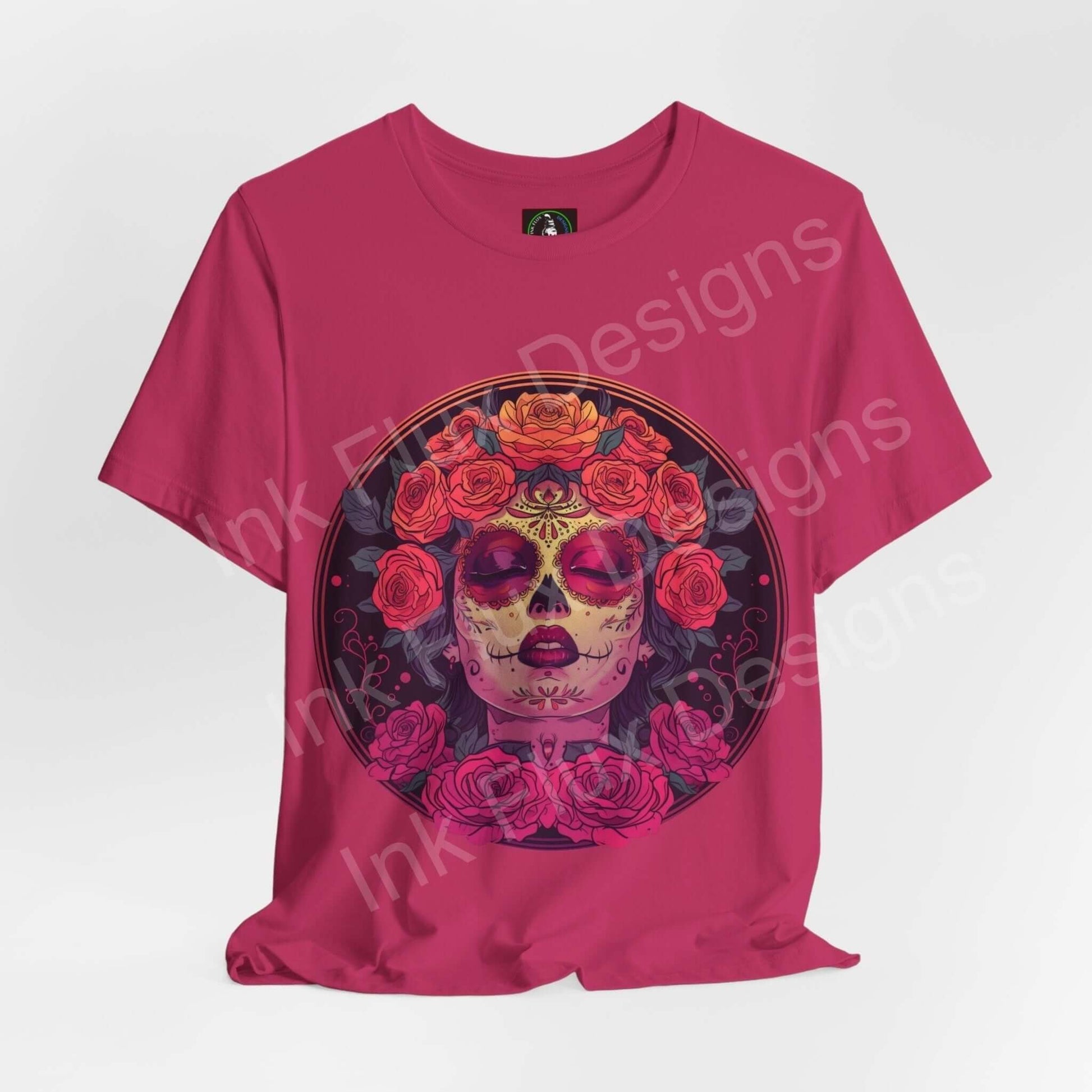 Pink Day of the Dead graphic tee featuring a bold DÃa de Muertos sugar skull design adorned with vibrant red roses, crafted from soft Airlume cotton.