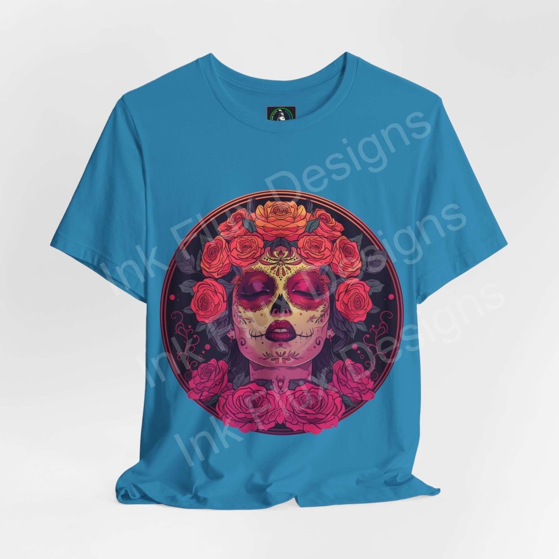 Blue unisex Day of the Dead graphic tee featuring a vibrant DÃa de Muertos skull design with rose embellishments.
