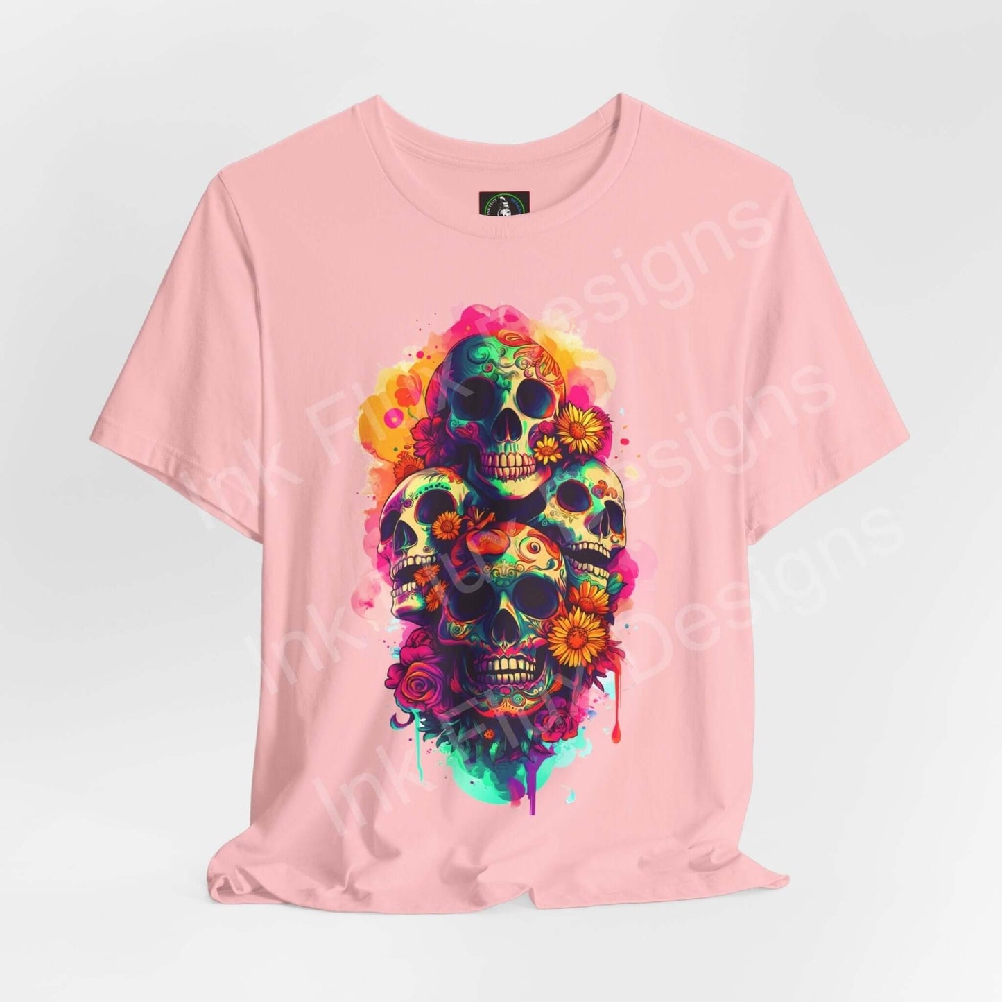 Pink Day of the Dead themed T-shirt featuring vibrant graphic skulls and flowers, suitable for DÃa de Muertos celebrations.