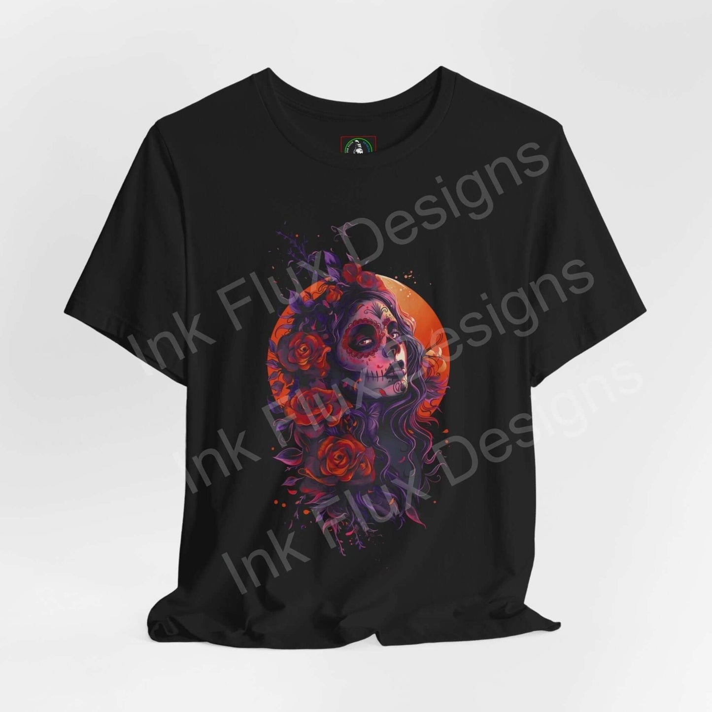 Day of the Dead themed graphic tee featuring a colorful skull and floral design on a black T-shirt, by Bella+Canvas for DÃa de Muertos.
