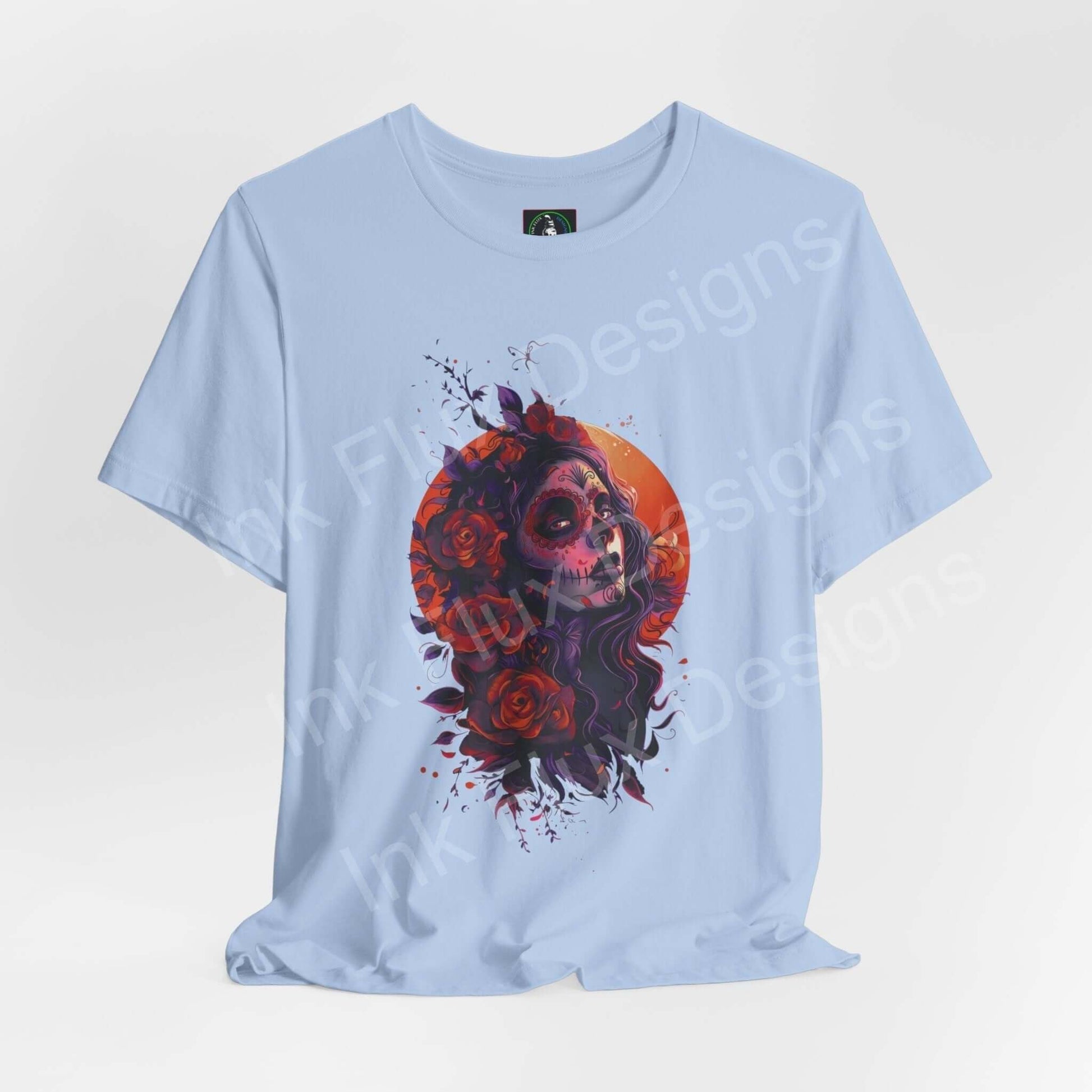 Light blue unisex T-shirt featuring a vibrant Day of the Dead graphic with skull and roses, ideal for DÃa de Muertos celebrations.