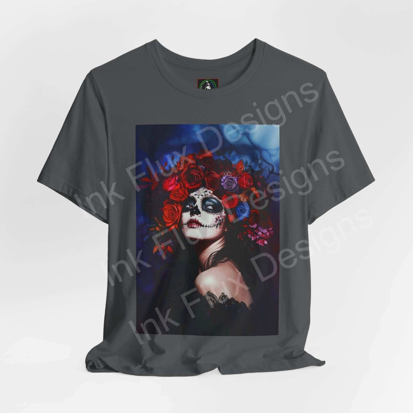 Day of the Dead themed T-shirt featuring a graphic of a woman with a skull makeup and red floral headband, perfect for DÃa de Muertos celebrations.