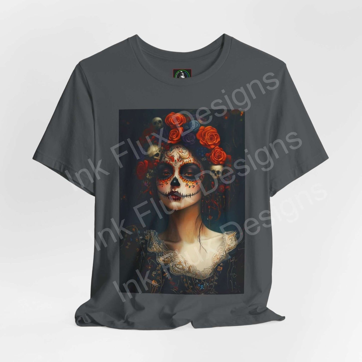 Charcoal gray T-shirt featuring a Day of the Dead Woman's portrait with floral accents and intricate face paint, from Bella+Canvas.