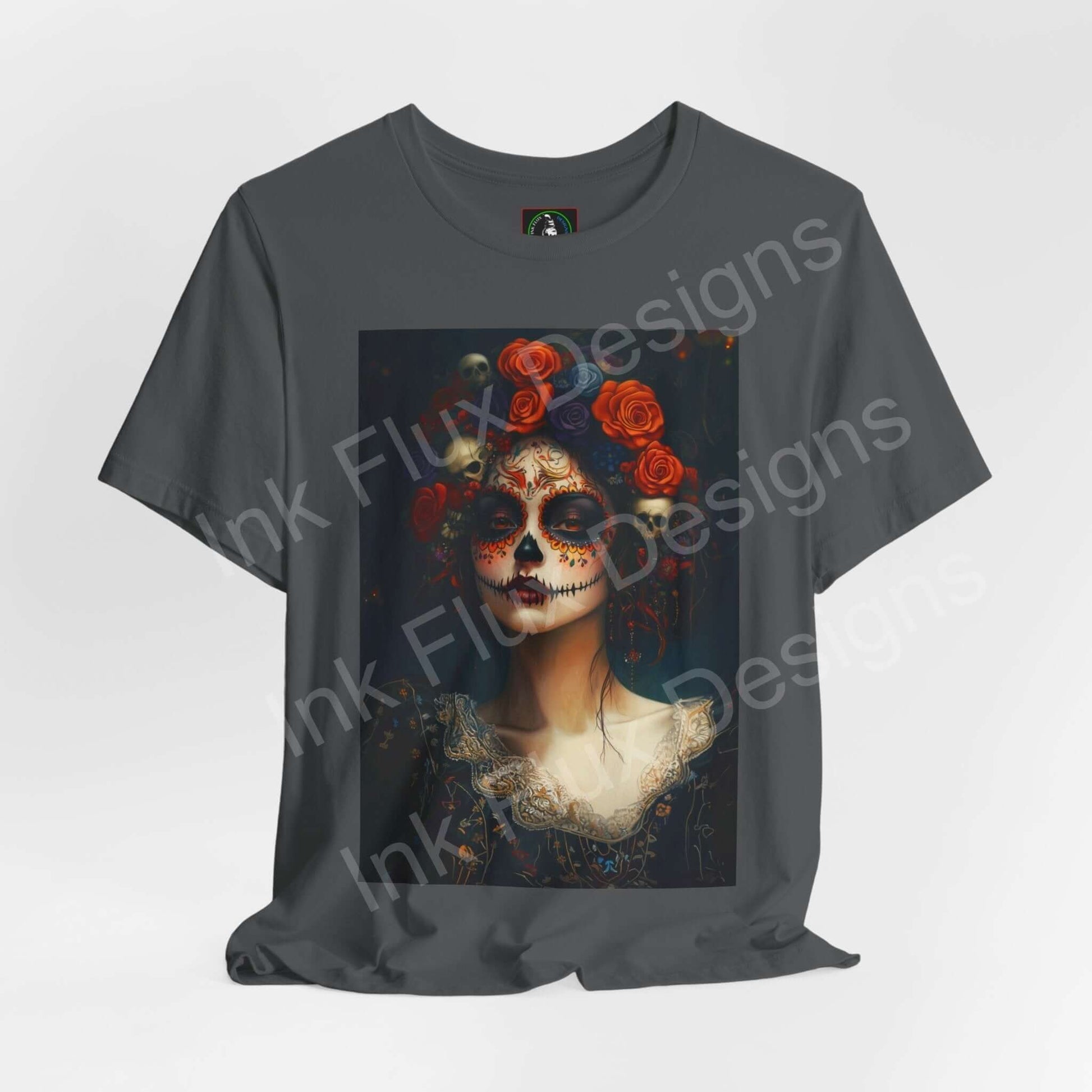 Charcoal gray T-shirt featuring a Day of the Dead Woman's portrait with floral accents and intricate face paint, from Bella+Canvas.