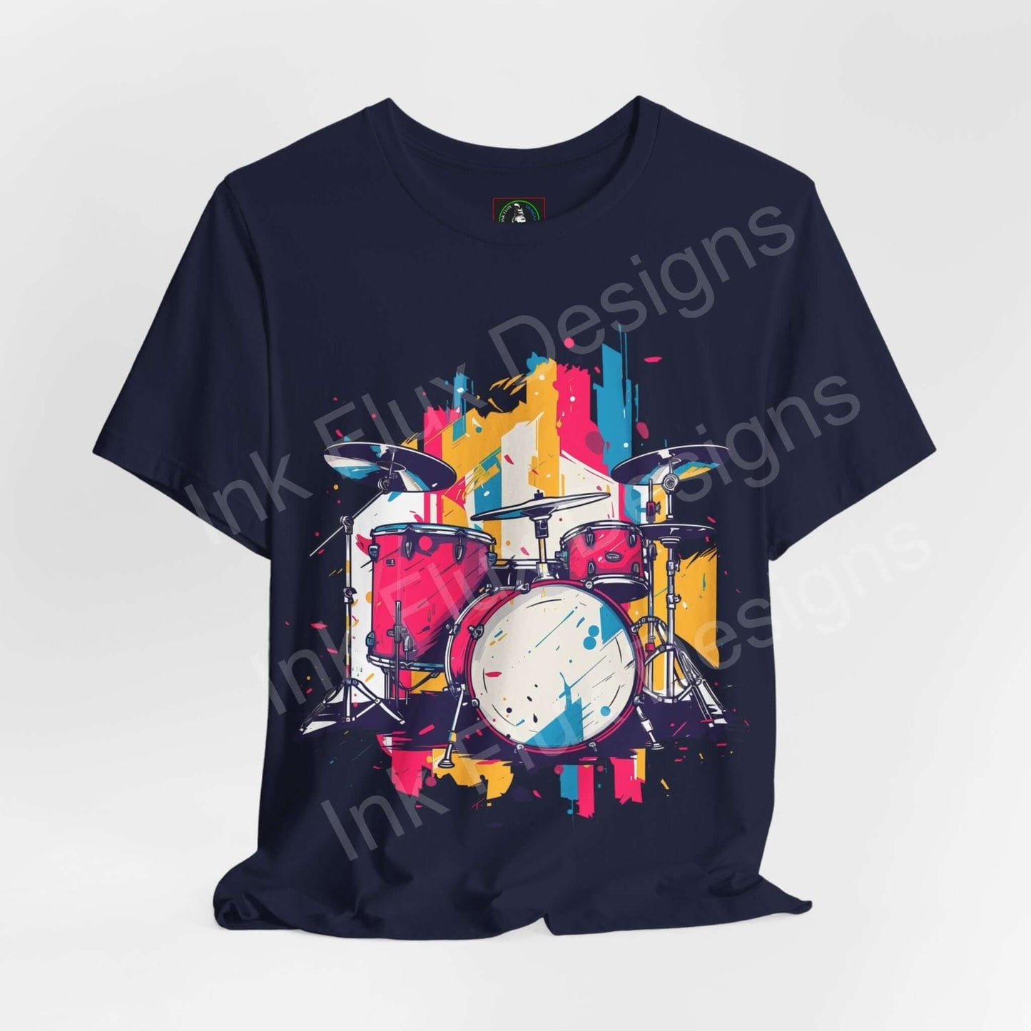Navy blue graphic tee featuring a vibrant, abstract drum set design in bold colors, showcasing style and comfort from Bella+Canvas.
