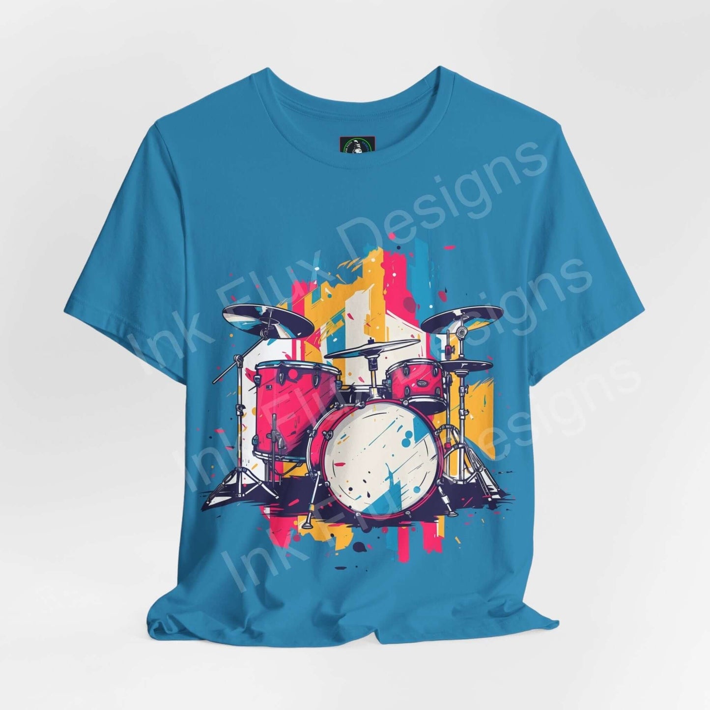Bold graphic tee featuring a colorful drum set design on a blue jersey T-shirt, perfect for music and fashion enthusiasts.