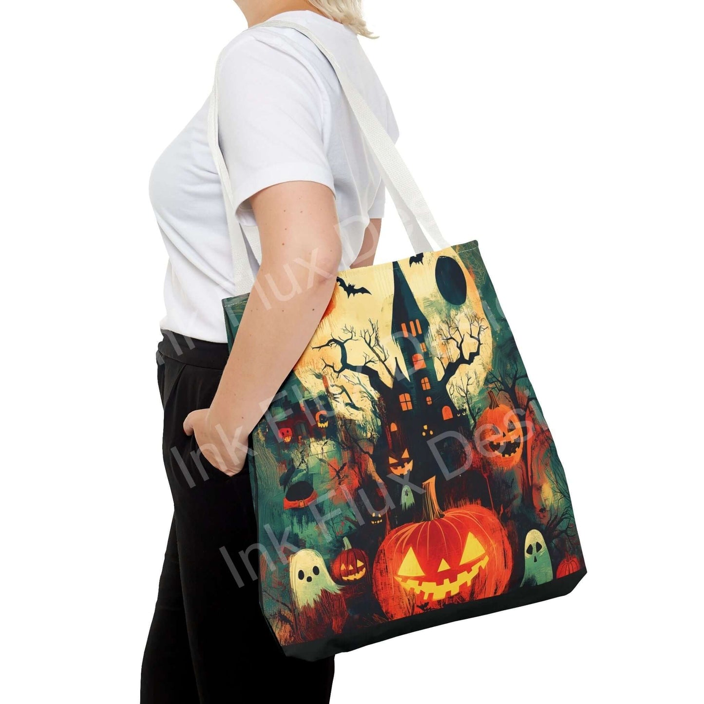 Woman carrying a Halloween-themed tote bag featuring a spooky design with pumpkins, ghosts, and a haunted house