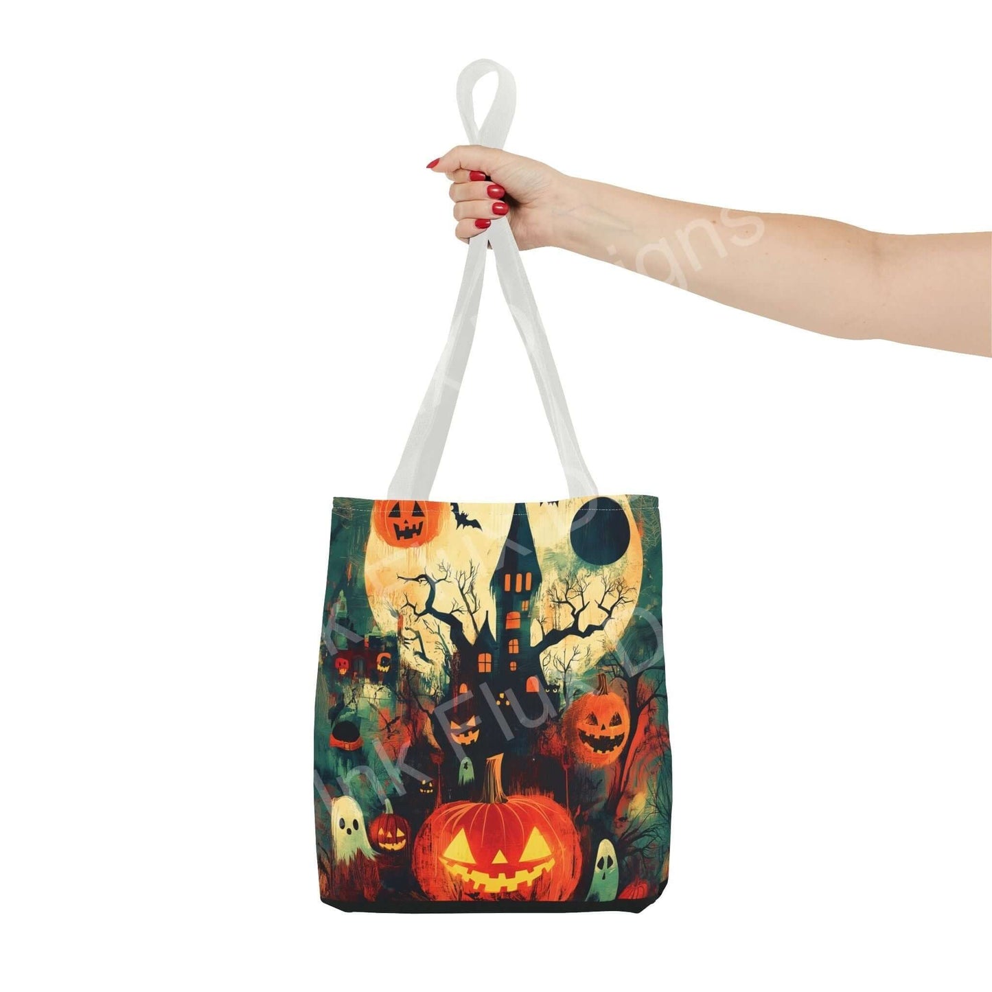 Hand holding a Halloween-themed tote bag featuring a spooky haunted house, pumpkins, and full moon design, perfect for festive occasions.