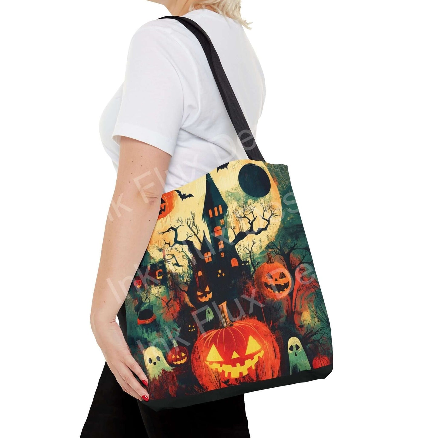 Woman carrying a Halloween-themed tote bag featuring a vibrant all-over print of spooky scenery with pumpkins and haunted house