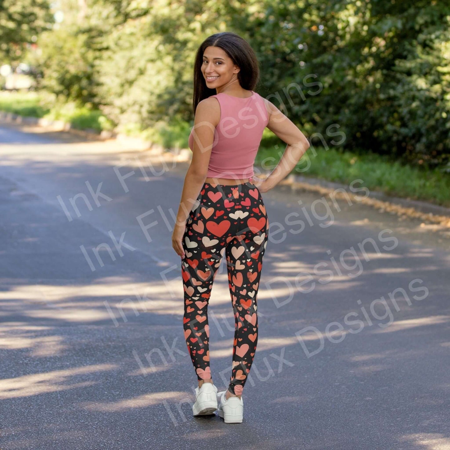 Woman wearing Hearts Collage Leggings with bold heart designs, posing on a tree-lined street, showcasing the stretchy and durable fabric.