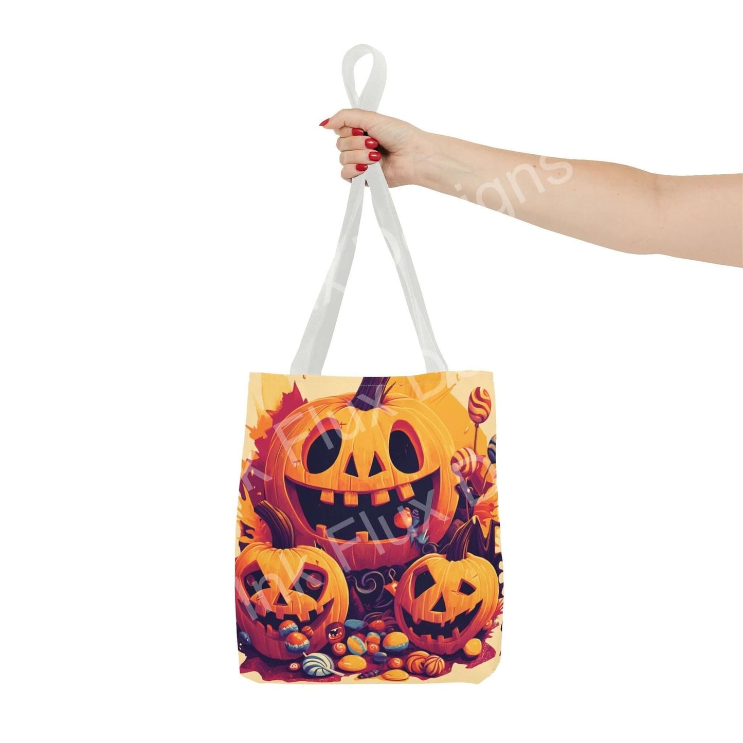 Woman's hand holding a Jack o' Lantern themed tote bag featuring colorful all-over Halloween print and sturdy white handles.