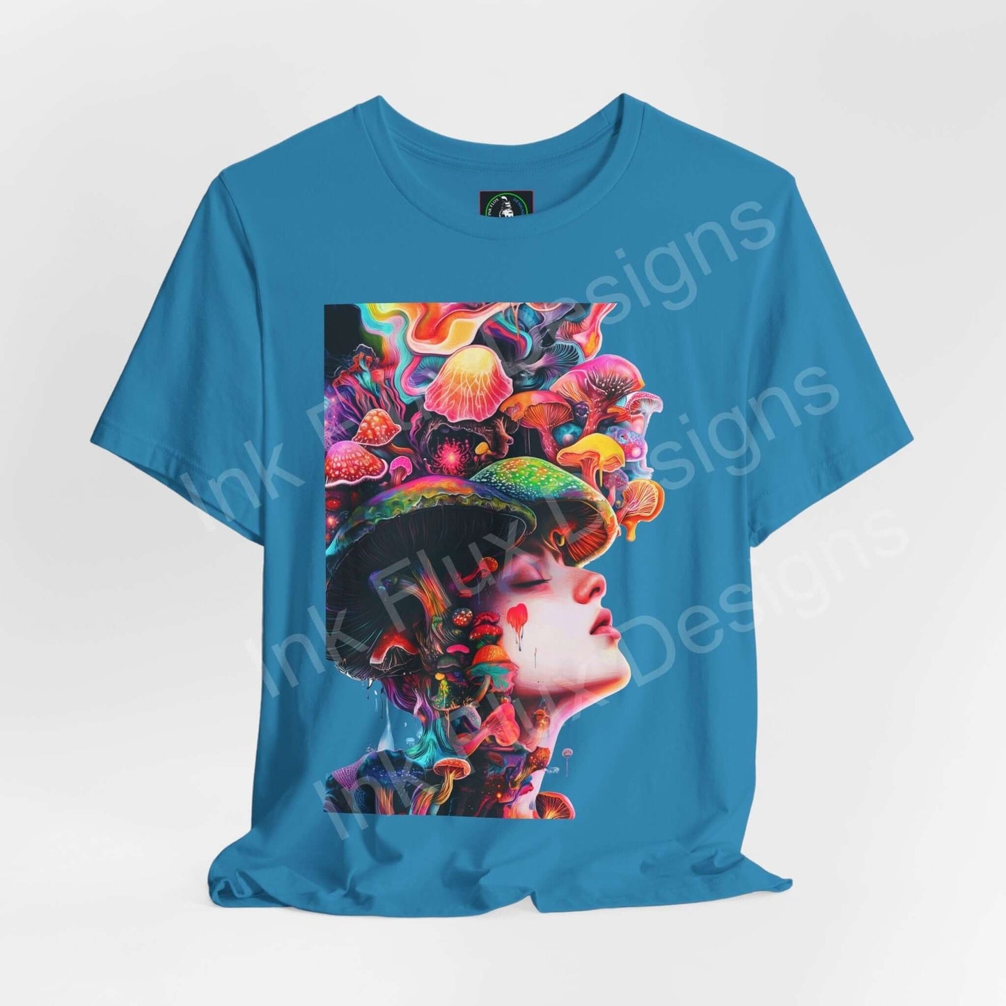Unisex blue T-shirt featuring a bold, psychedelic graphic of a woman adorned with vibrant mushrooms and trippy elements, from Bella+Canvas.