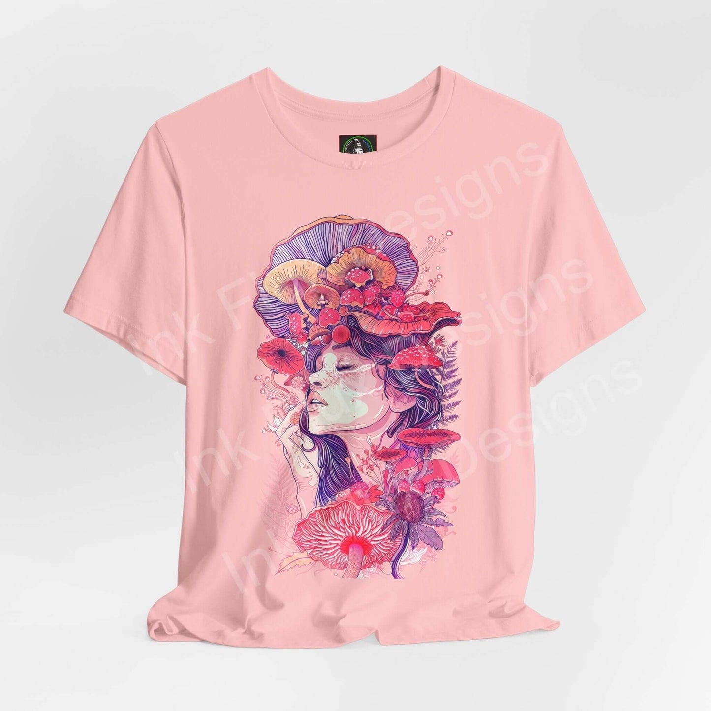 Pink unisex T-shirt featuring a bold, psychedelic graphic of a woman adorned with vibrant mushroom and floral designs, in a trippy, artistic style.
