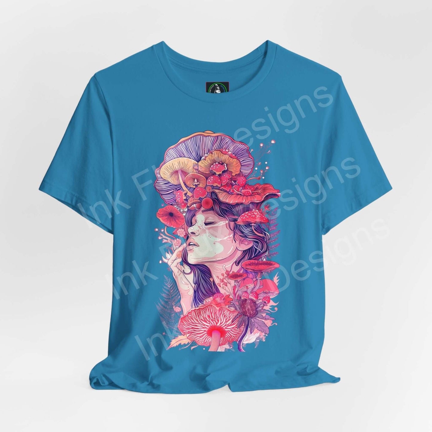 Bold graphic tee featuring a psychedelic 'Mushroom Lady VII' design in vibrant reds and pinks on a blue unisex T-shirt.