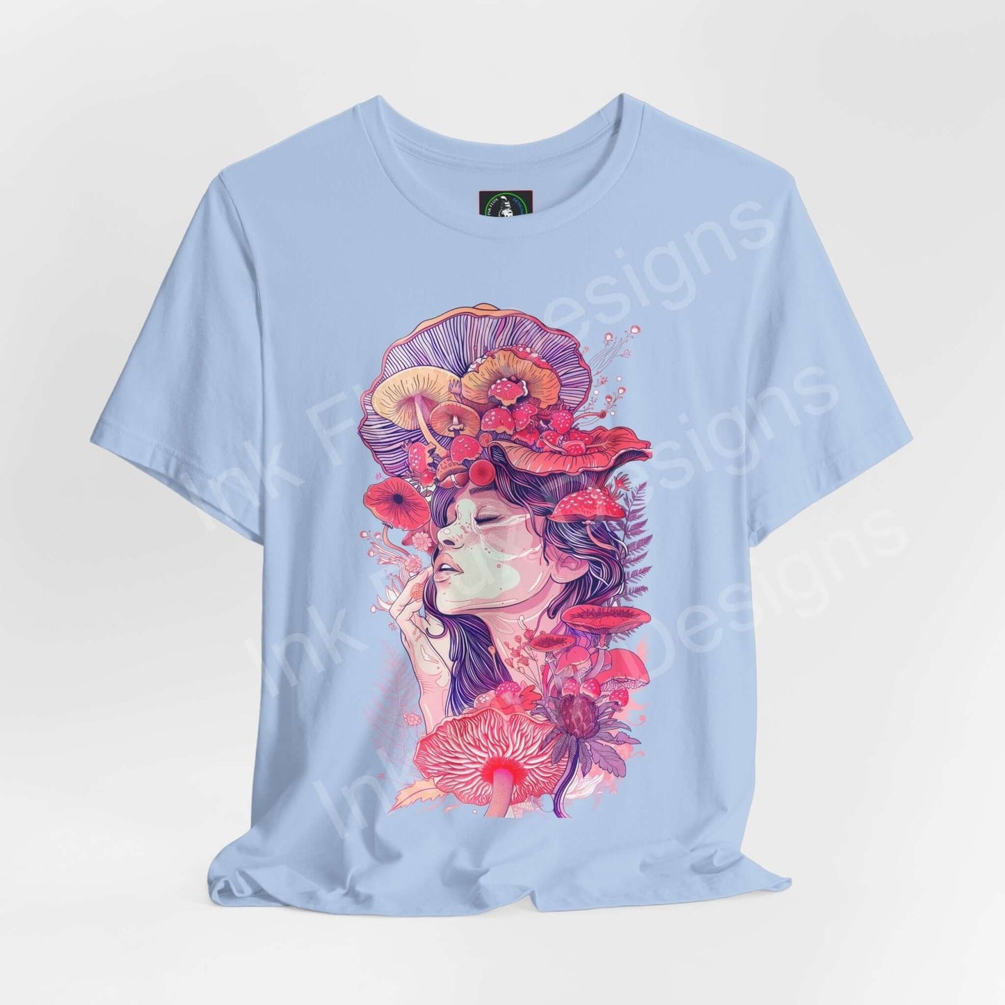 Light blue unisex T-shirt featuring a bold, psychedelic graphic of a woman with mushroom and floral motifs in vibrant red and pink tones.