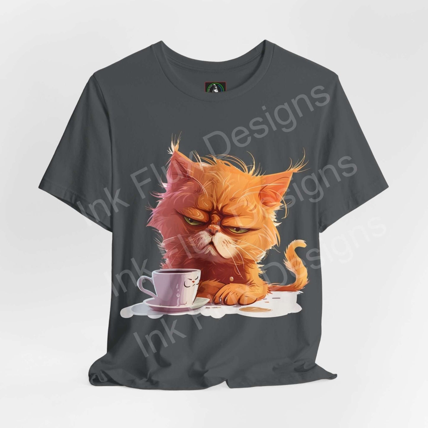 Unisex gray T-shirt featuring a graphic of a grumpy orange cat glaring at a coffee cup, ideal for cat lovers and T-shirt enthusiasts.