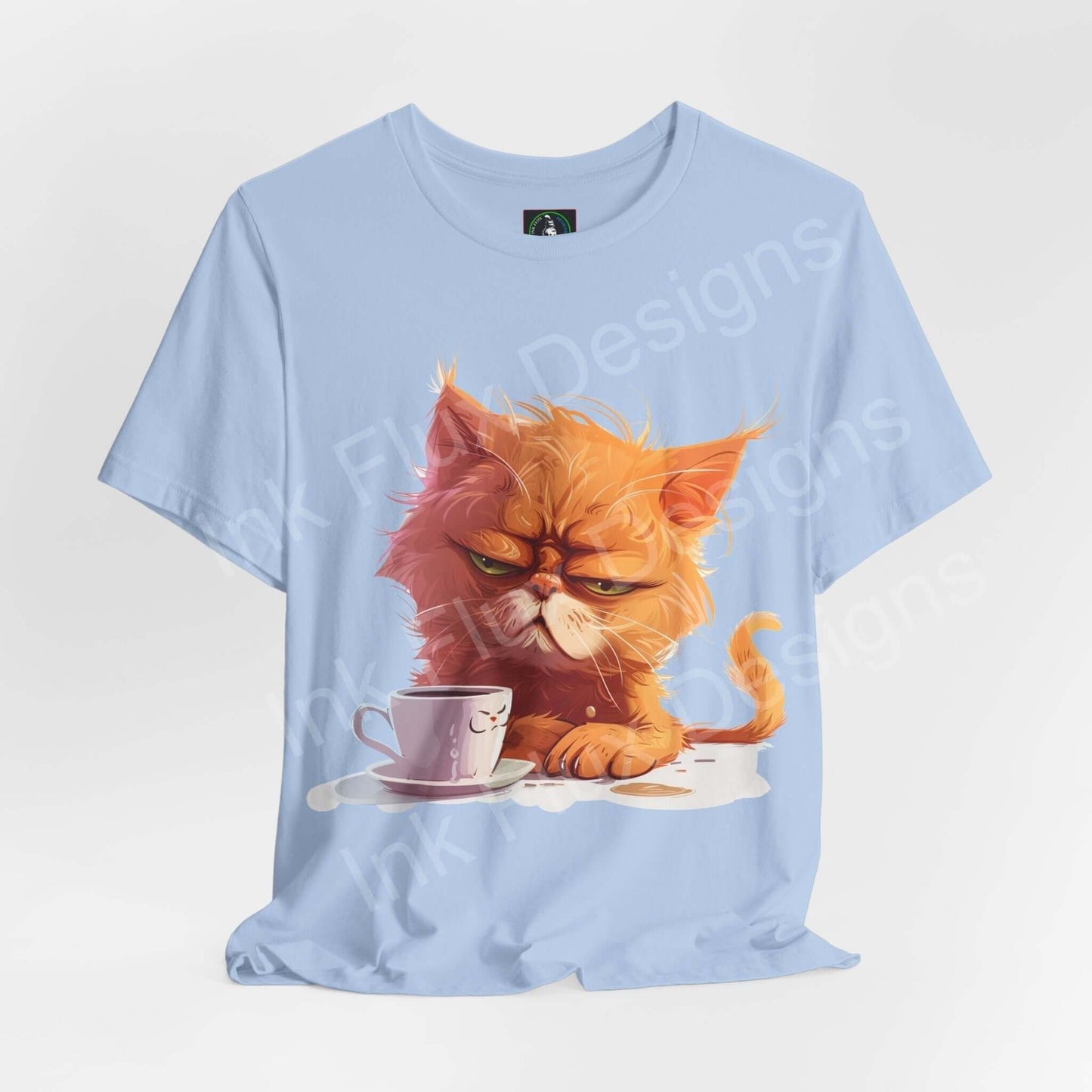 Light blue unisex T-shirt featuring a graphic of a grumpy orange cat with a coffee cup, titled "Not a morning cat." Perfect blend of comfort and style.