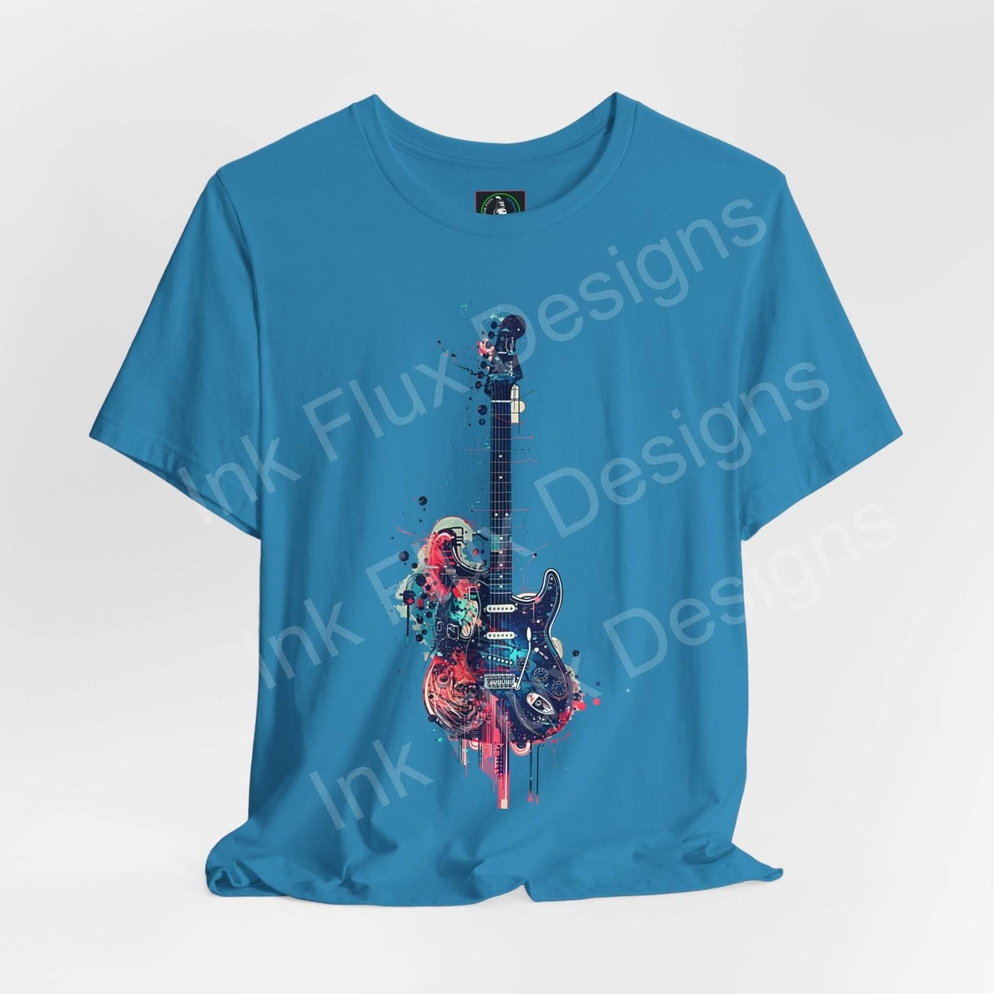 Unisex blue jersey T-shirt featuring a bold graphic print of a paint-splattered guitar, crafted from breathable Airlume cotton by Bella+Canvas.