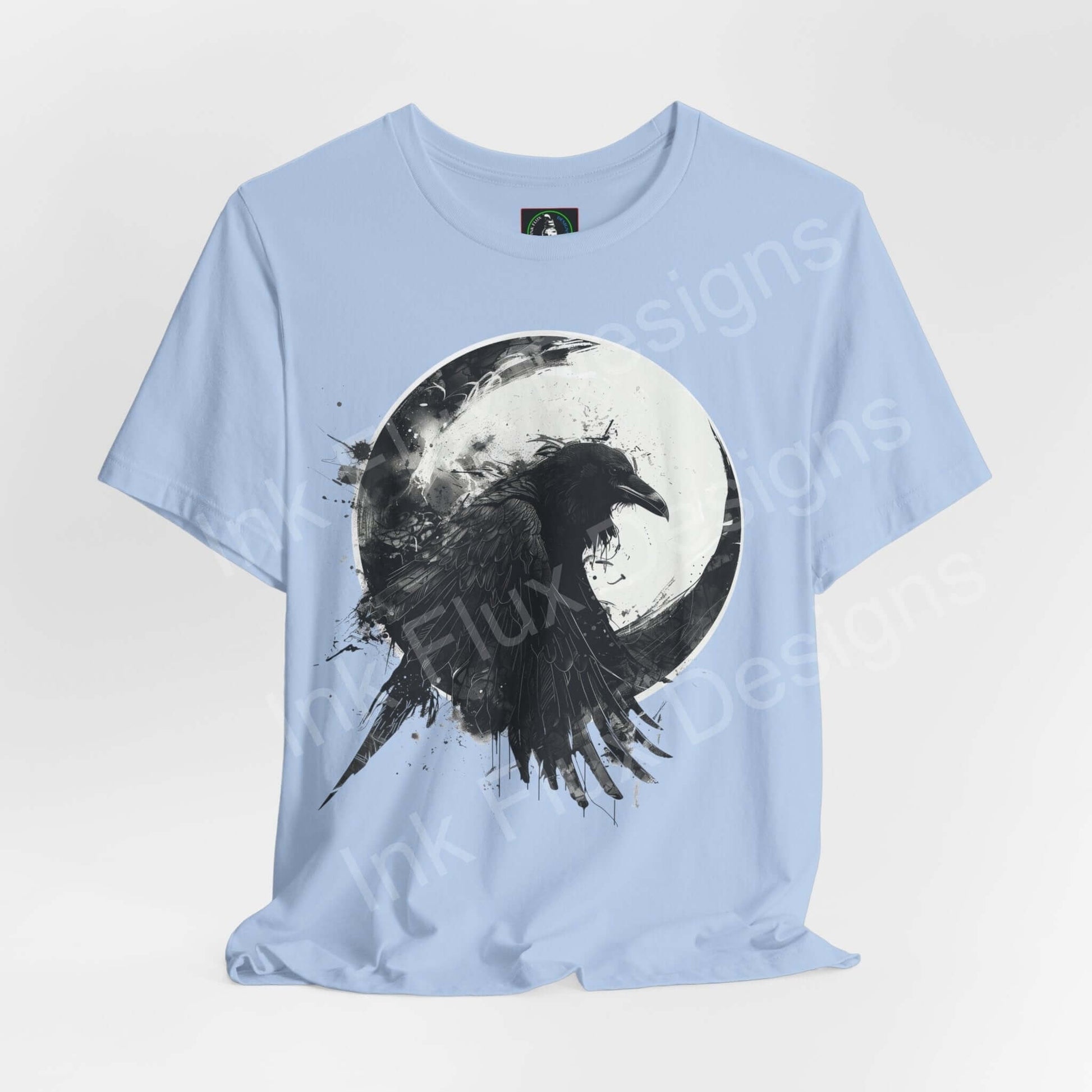 Light blue unisex T-shirt featuring a graphic of a raven against a moon, embodying spirit animal theme, from Bella+Canvas.