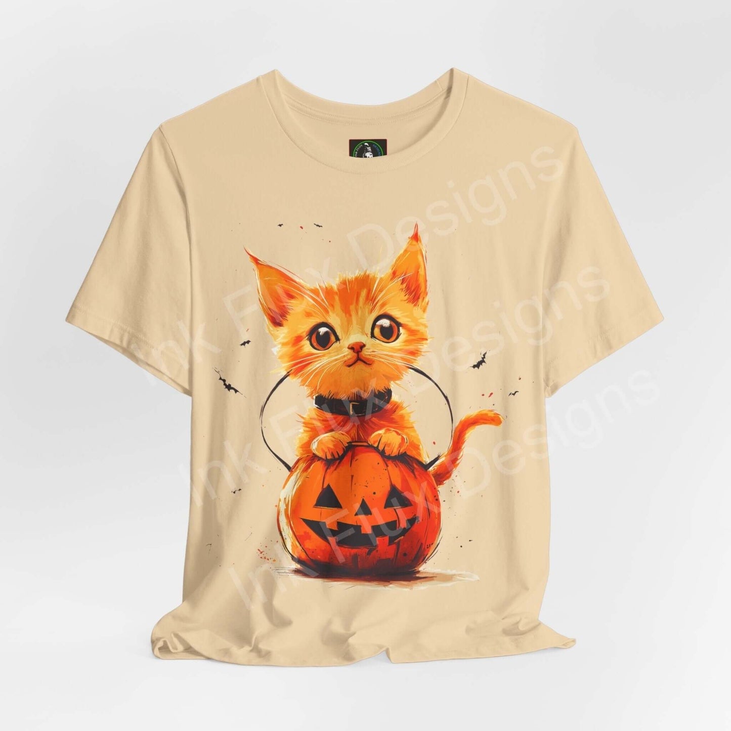 Beige T-shirt featuring a graphic of an orange cat emerging from a Halloween pumpkin, designed for stylish comfort and durability.