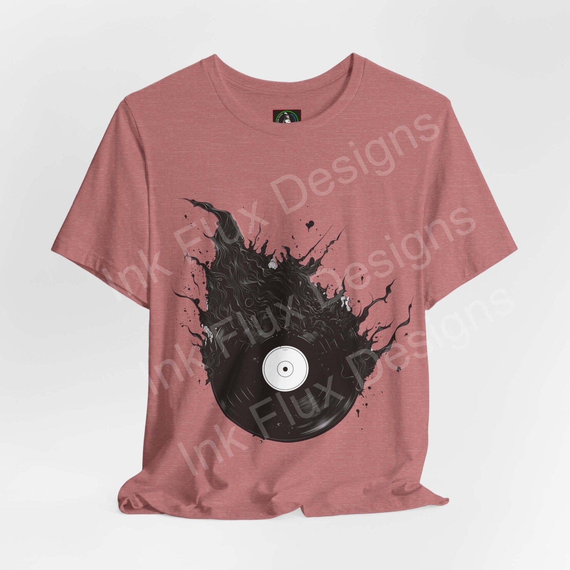 Unisex rose T-shirt with bold graphic of a vinyl record emerging from black splatter, crafted by Bella+Canvas, showcasing sustainable and ethically made fashion.
