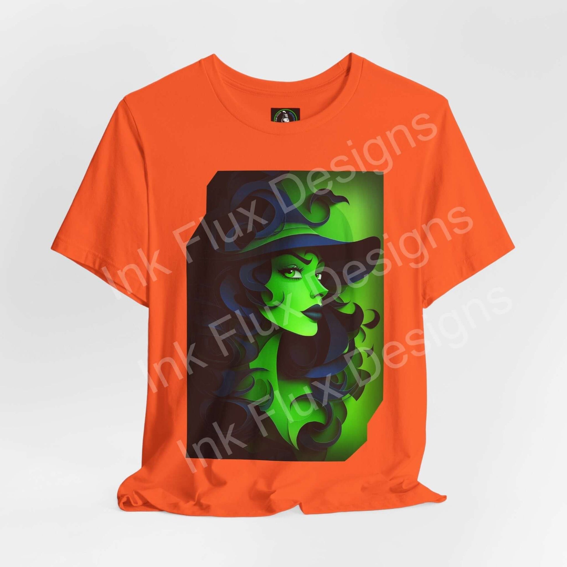 Green Witch T-Shirt featuring a vibrant paper cut-out design on an orange background.