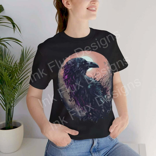 Woman wearing a black Raven T-shirt from the Spirit Animals Collection, artistic raven design visible, casual style.