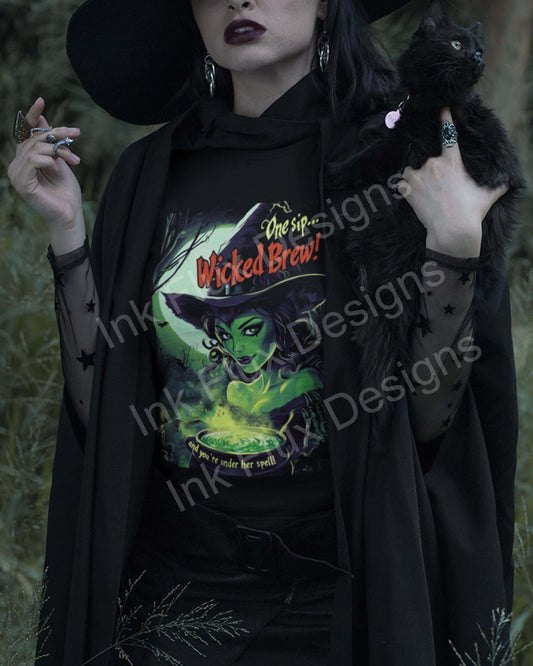 Woman in a black hat holding a black cat, wearing a Halloween T-shirt with a witch design titled "One Sip Wicked Brew"