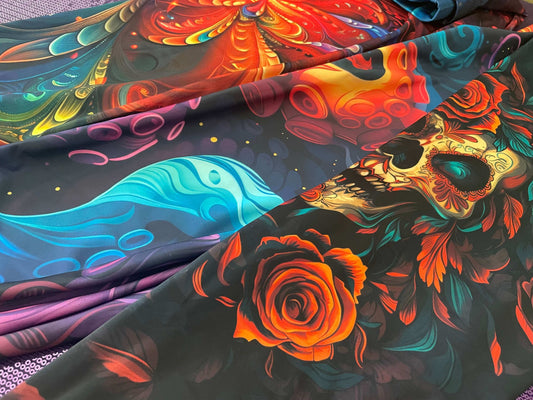 Bold and vibrant women's leggings featuring colorful skull and floral designs laid out on a surface.