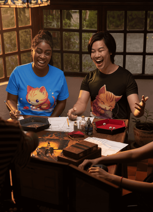 Two friends laughing and playing tabletop game, wearing 'Cat and Mouse' and 'Cat and Yarn II' T-shirts in a cozy room.