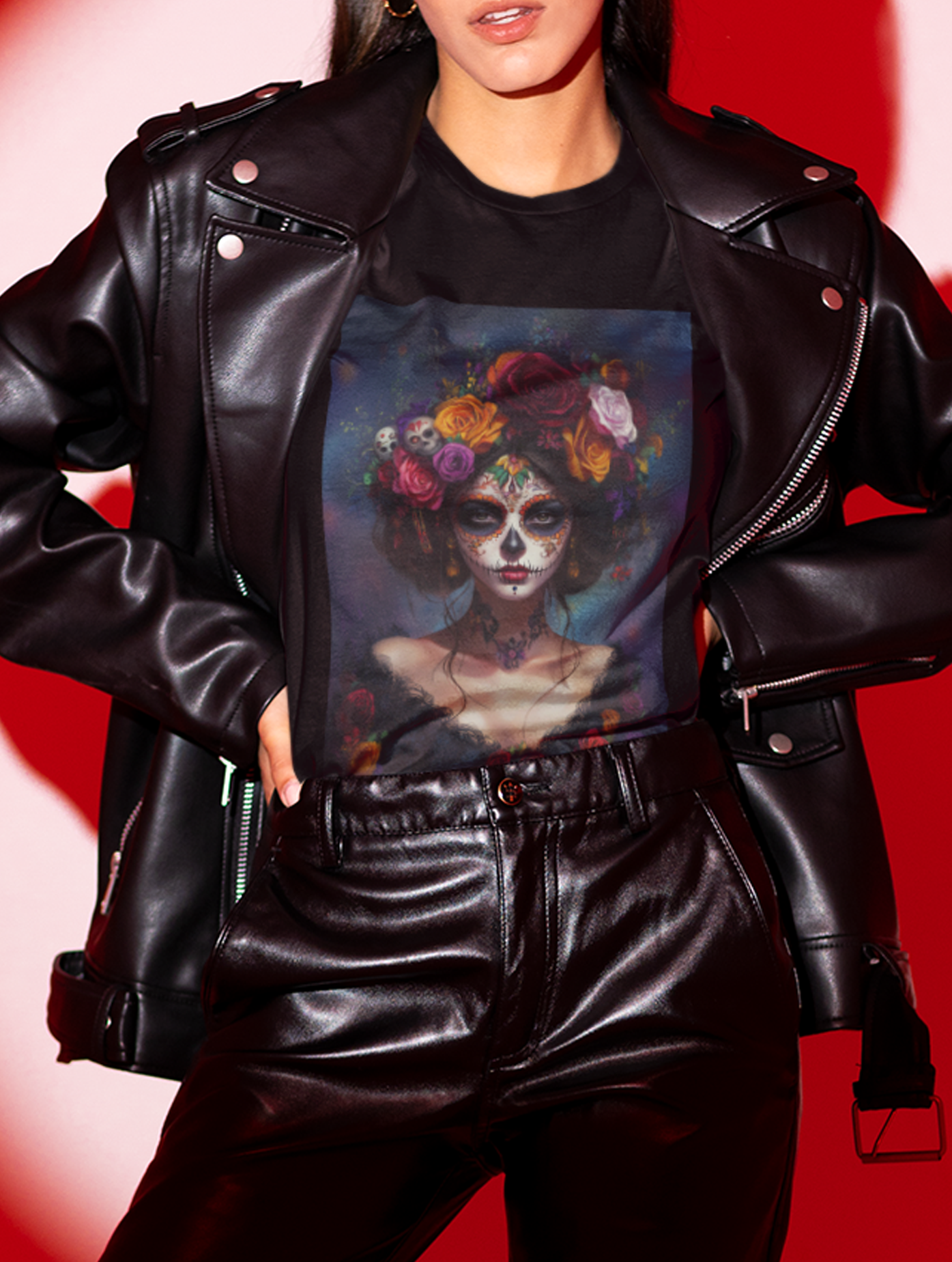 Woman in black leather jacket and pants wearing a Day of the Dead themed t-shirt with colorful corpse paint design.